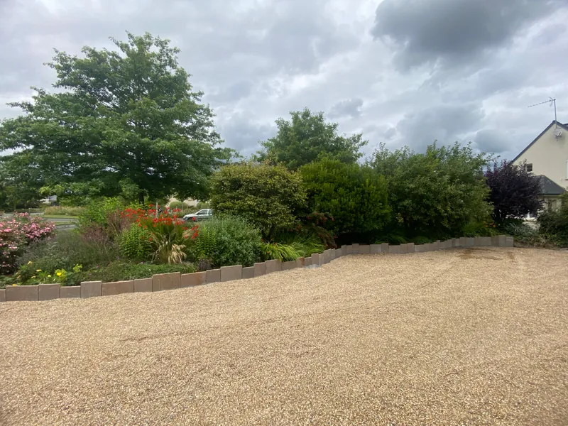Amenagement paysager complet avec allee en gravillon et massifs vegetaux