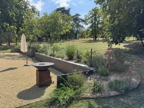 Terrasse en gravier stabilise avec muret en acier corten et massifs fleuris - paysagiste Angers